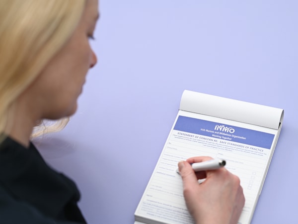 Female nurse sitting side profile filling out a statement of concern